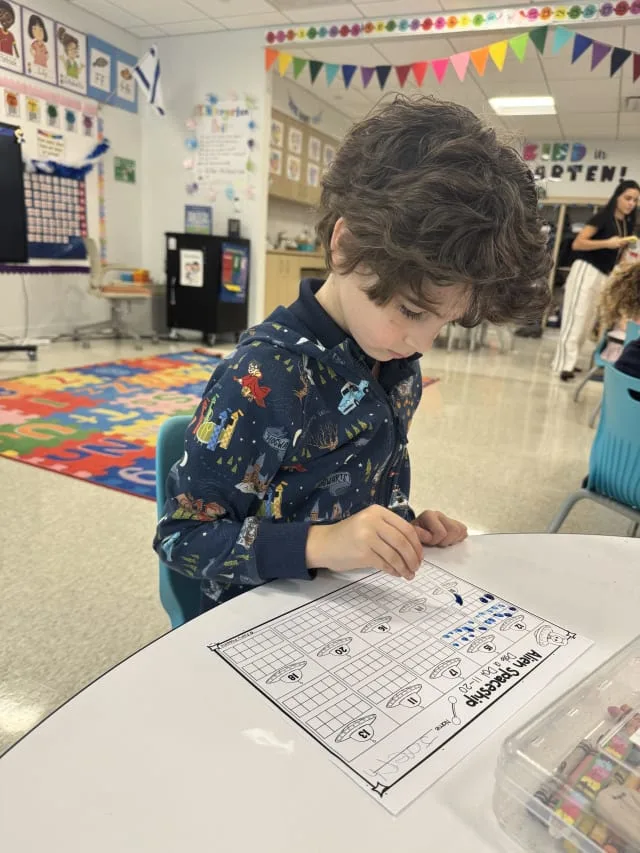 boy completes a worksheet about numbers