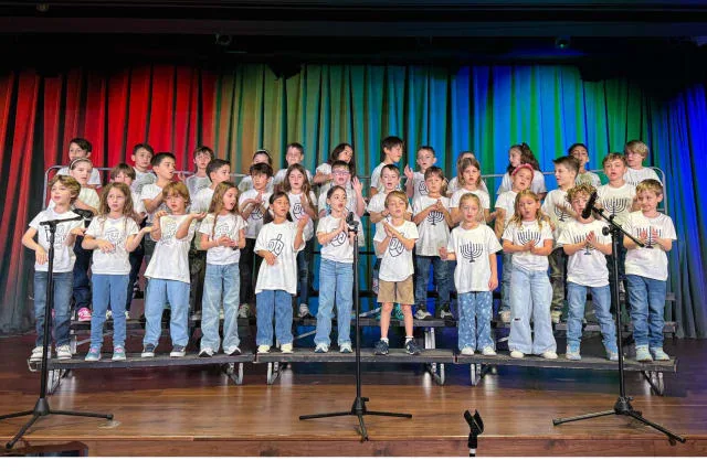 group of first graders on stage singing