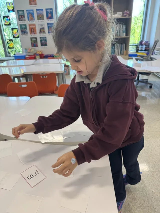 girl uses flashcards to learn Hebrew
