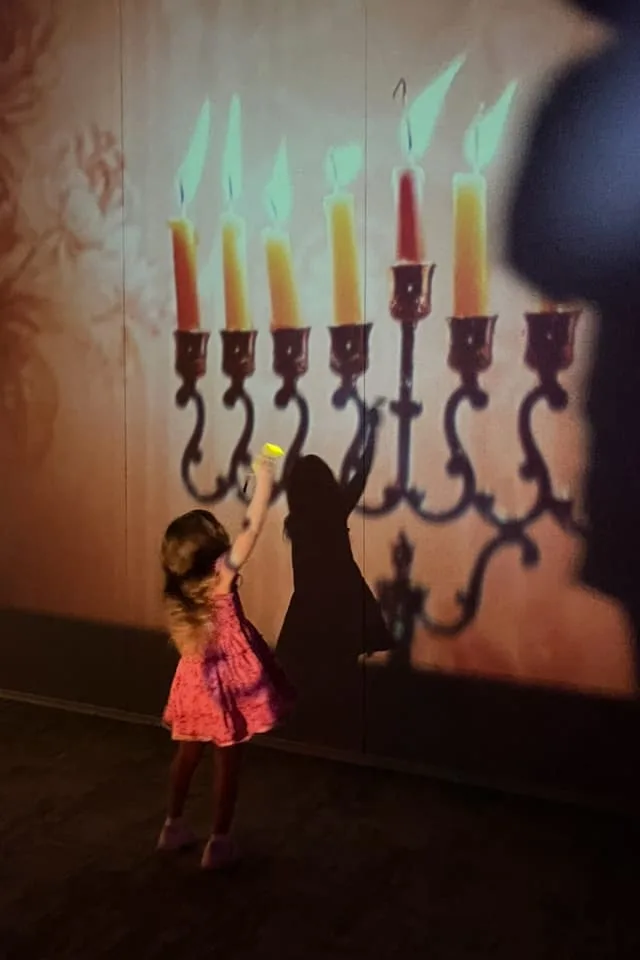 girl dances with menorah
