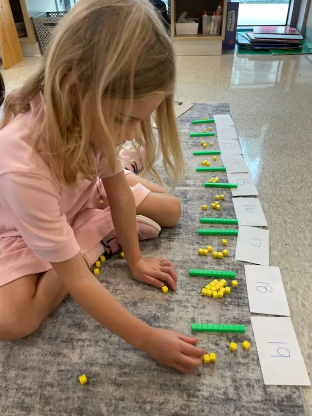 girl uses colored blocks to learn counting