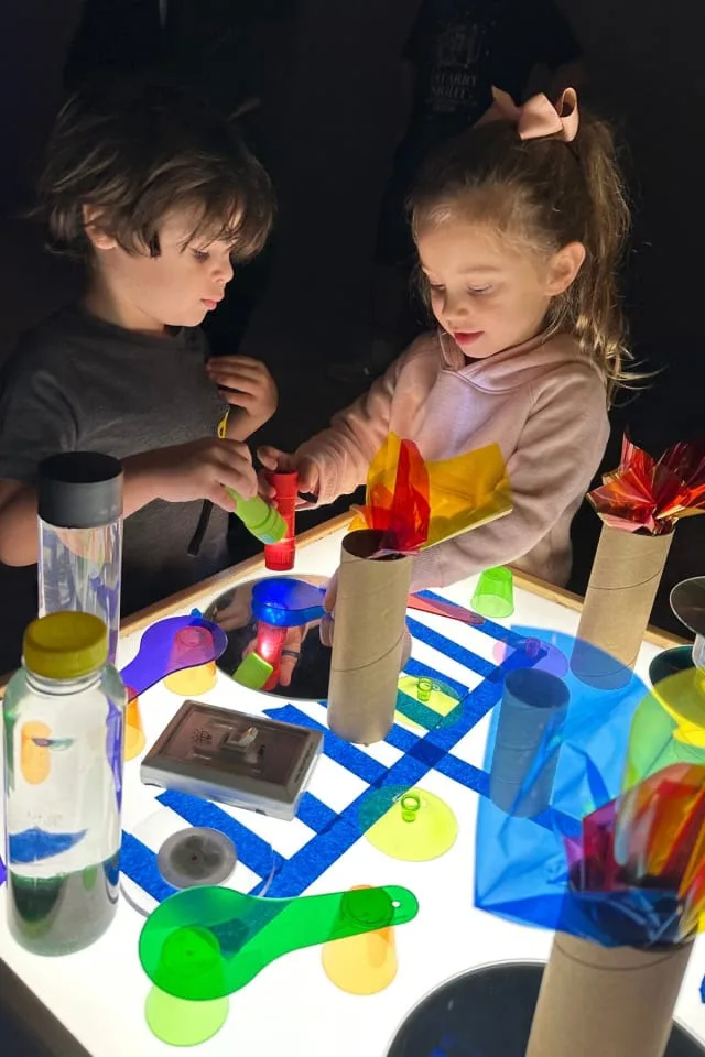 kids play with translucent toys on light table